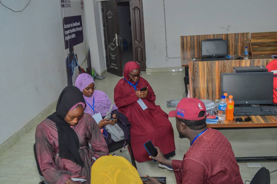 A facilitator mentoring participants during a digital skills training session